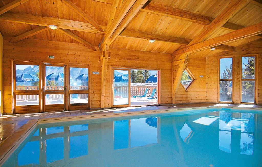 a swimming pool in a house with a wooden ceiling at Résidence Odalys L'Orée des Pistes in Le Dévoluy