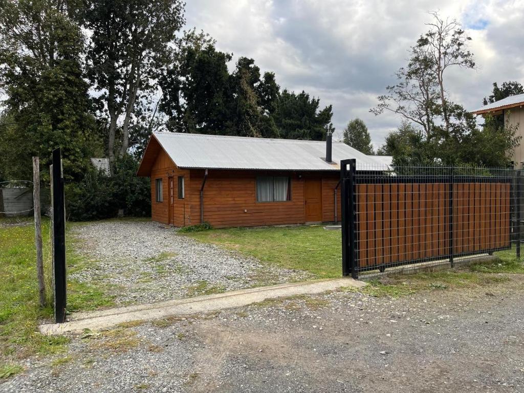 a wooden cabin with a fence in front of it at Cabañas arca 2 in Pucón