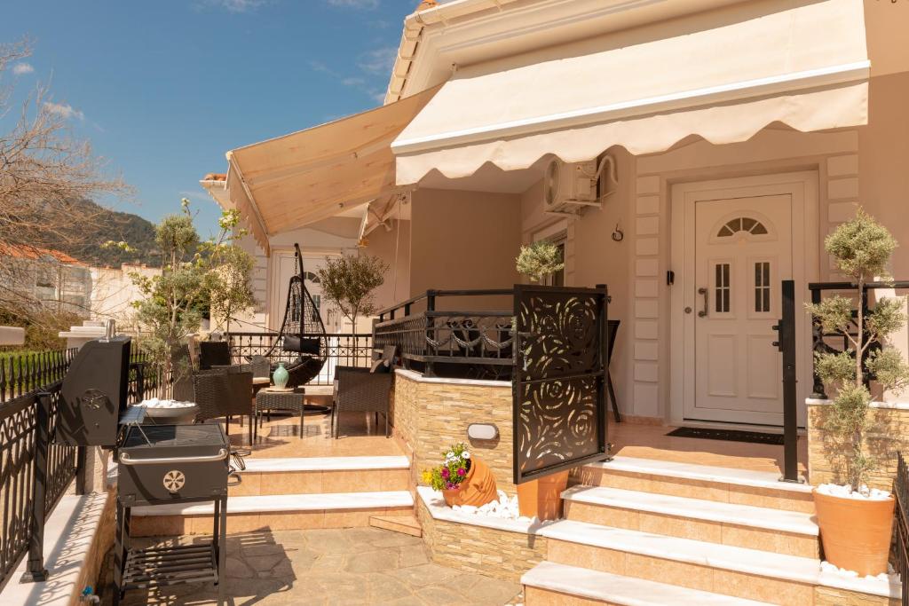 a patio with a white door and stairs to a house at F Tsimas apartment 1 in Skala Potamias