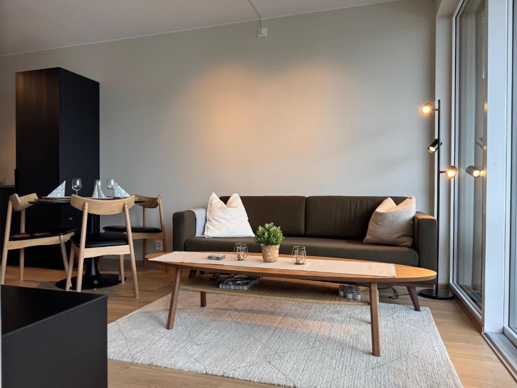 a living room with a couch and a table at Apartment by Kokstad tram in Bergen