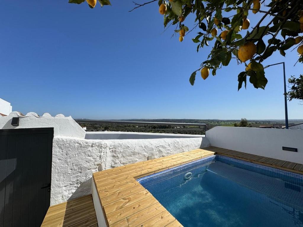a swimming pool on the side of a house at Á-do-Couve in Alvito