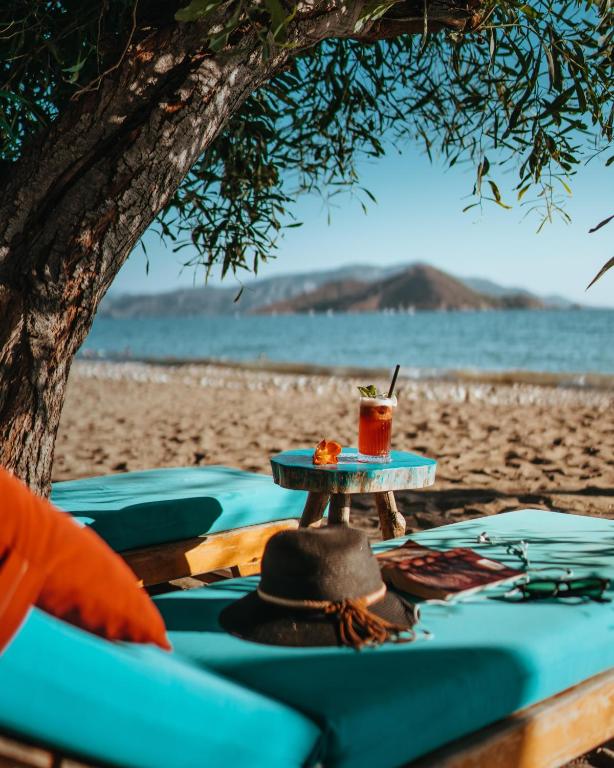 ein Tisch am Strand mit einem Getränk darauf in der Unterkunft Yonca Lodge in Fethiye