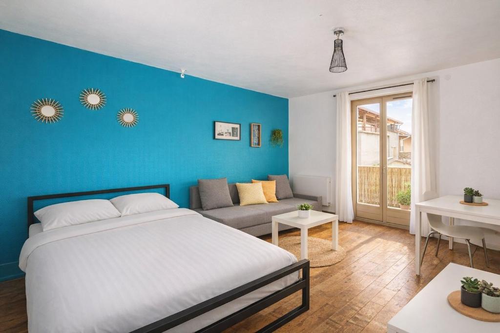 a bedroom with a bed and a blue wall at Studio cosy avec extérieur CHU in La Tronche
