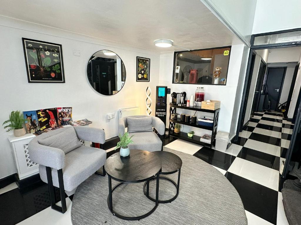 a living room with two chairs and a table at Amsterdam Hotel in London