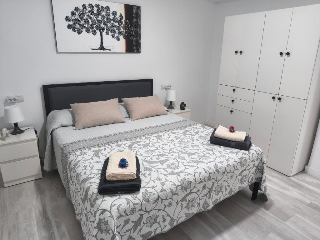 a bedroom with a bed with a tree on it at Apartamento Grao in Gandía