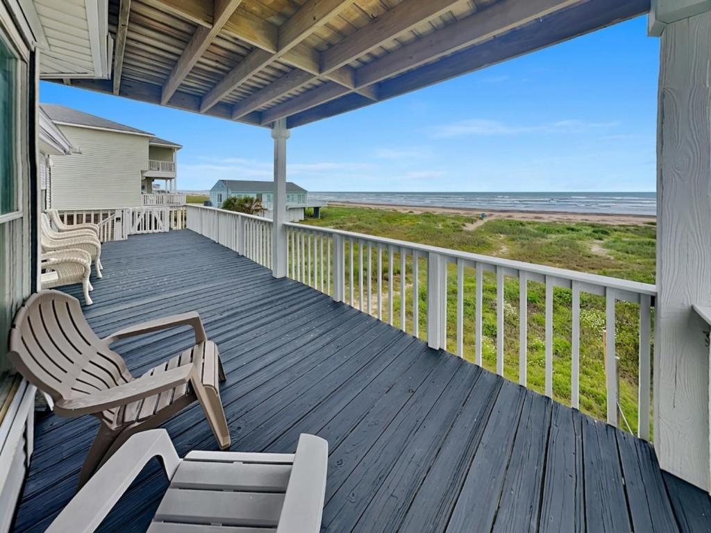 a porch with chairs and a view of the ocean at Whispering Sands Beachfront in Galveston