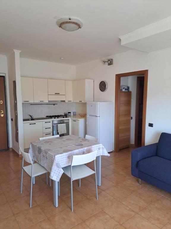 a kitchen with a table and chairs and a blue couch at Campania Home in Terni