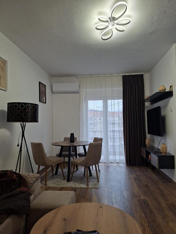 a living room with a table and a ceiling fan at Apartman Ivan Trebinje in Trebinje