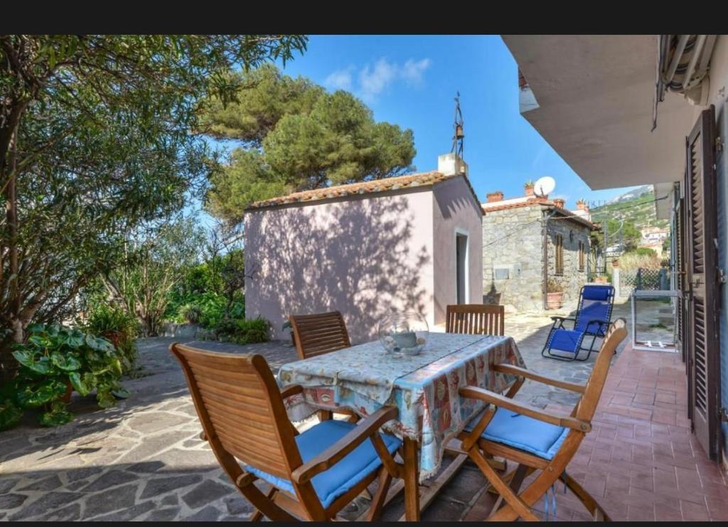 a table and chairs on the patio of a house at Casa Gaia a soli 20 mt dal mare in Pomonte