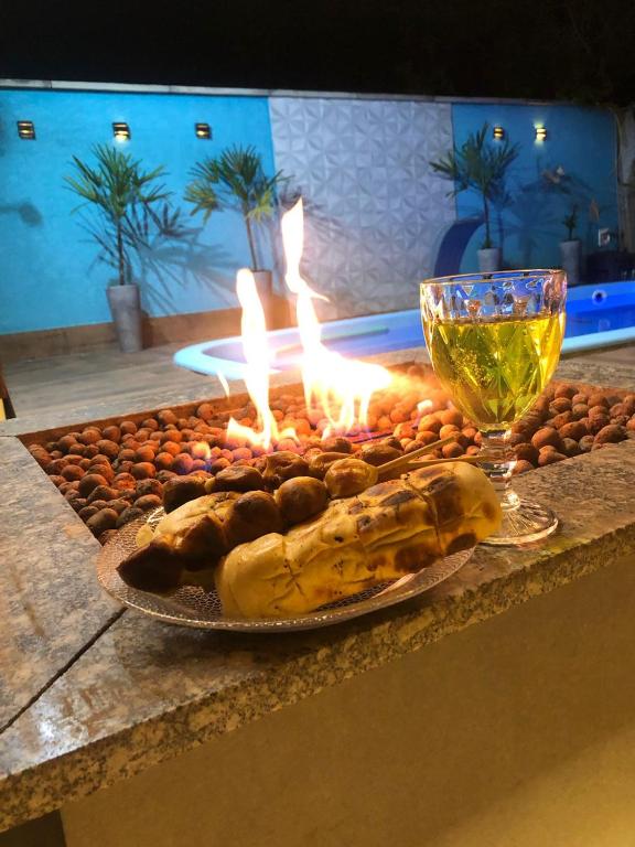 a table with a plate of food and a glass of wine at Onde o verão nunca termina! in Peruíbe