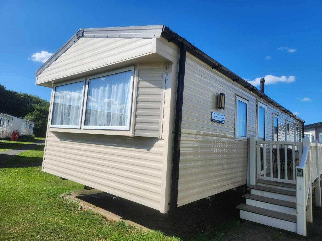 a white tiny house sitting in a yard at Nutmeg golden sands haven in Mablethorpe