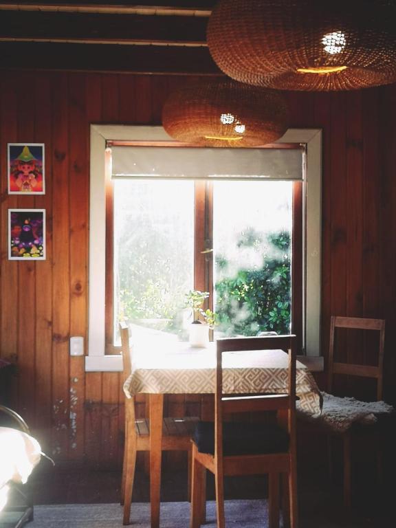 a table and a window with a table and chairs at Casa del Estero in Pucón