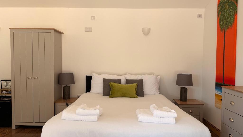 a bedroom with a white bed with towels on it at Converted Barn Studio with Private En-Suite in Horspath