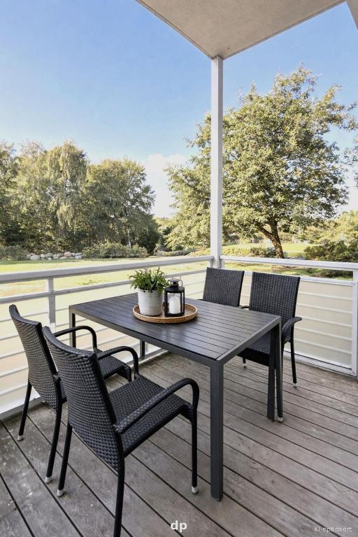 a patio table and chairs on a deck with a view at DUENENROSE App Nr 03 max 3 Pers in Dierhagen