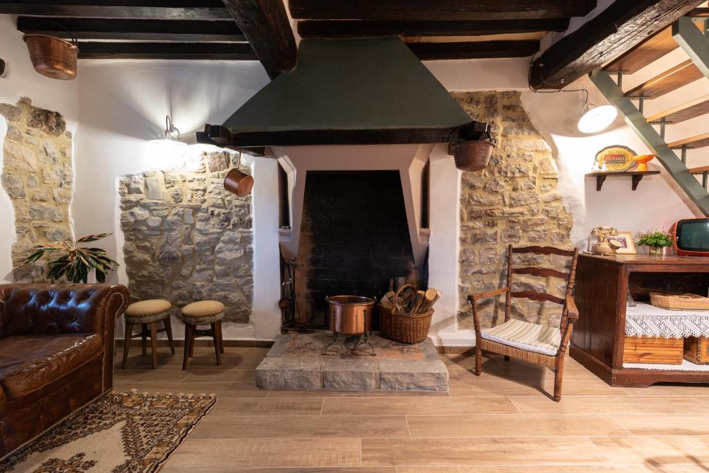 a living room with a stone fireplace and a couch at RoncoBèrtolo R&B in Loiano