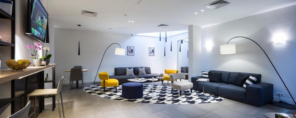 a living room with blue furniture and yellow chairs at Livris Hotel in Zagreb