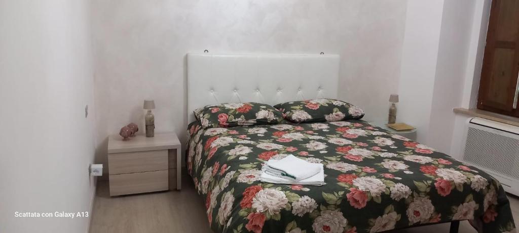 a bedroom with a bed with a floral bedspread at Kylix Home in Campobasso