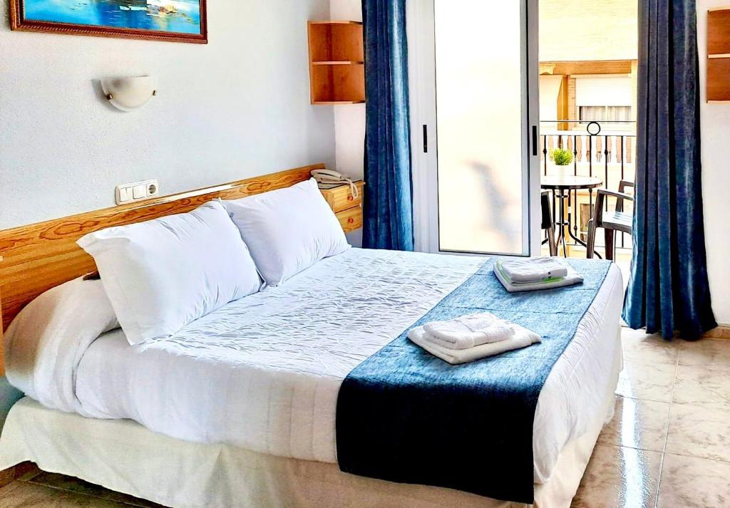 a bedroom with a bed with two towels on it at Hotel Alaska in San Pedro del Pinatar