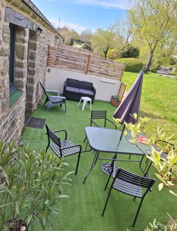 a patio with a table and chairs on the grass at Studio 11, Draps, Linge, Wifi # Longère Bretonne#Morbihan in Sulniac