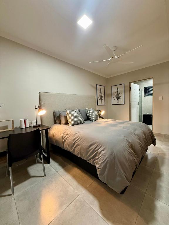 a bedroom with a large bed with a desk and a ceiling at Executive Suite South Fork in Kimberley