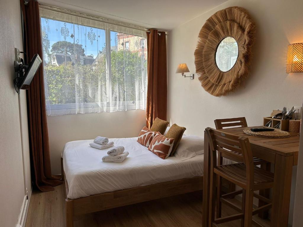a bedroom with a bed and a desk and a window at Studio avec accès plage et mer in Dinard