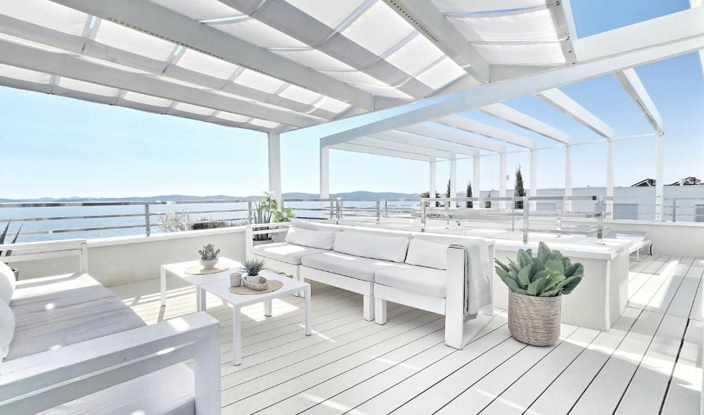 a balcony with white furniture and a view of the ocean at Terra & Salt in Bibinje