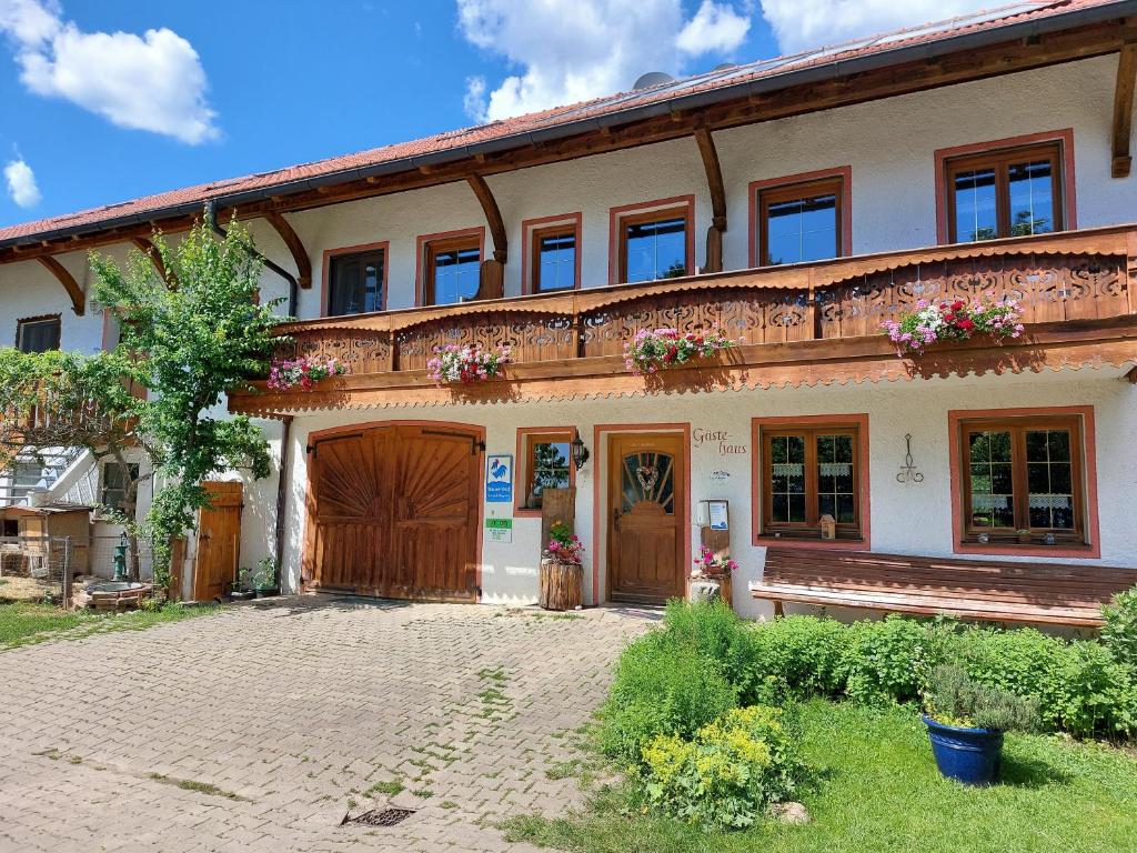 a large house with wooden doors and flowers at Wagnerhof in Au am Inn