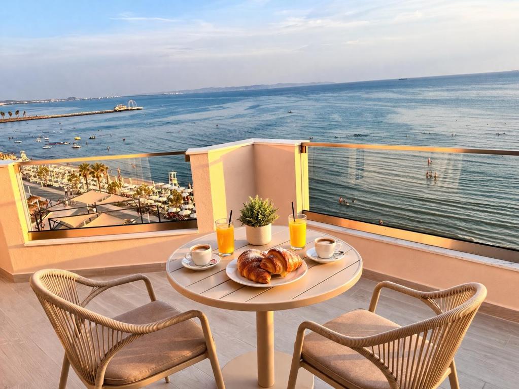 a table with a plate of food on a balcony at Fluctus Apartments in Durrës