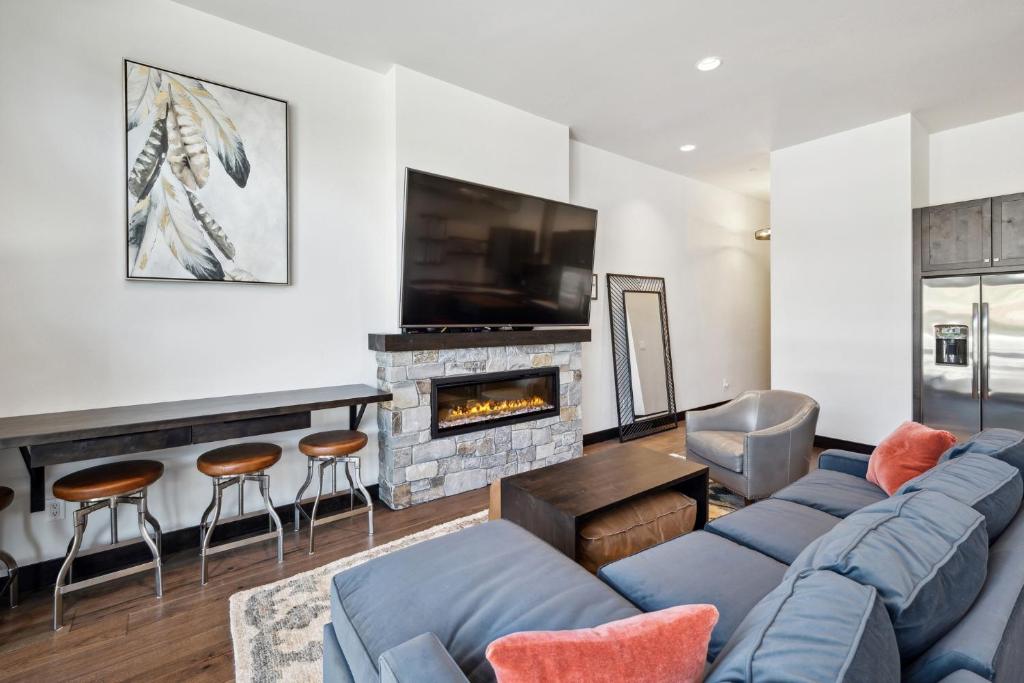 a living room with a blue couch and a fireplace at Downtown Gem in Whitefish