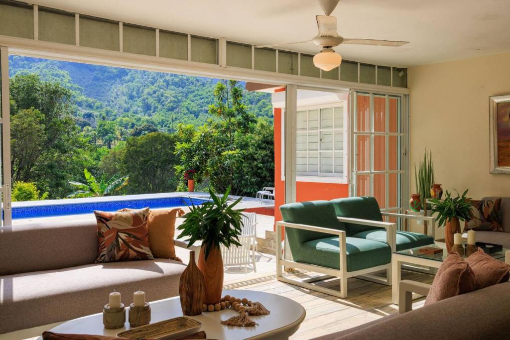 a living room with a couch and chairs and a large window at Spacious Villa in La Cuaba, Pool in Pedro Brand