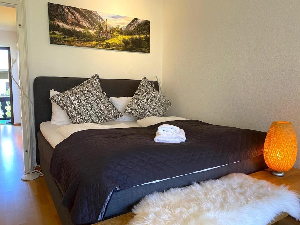 a bedroom with a large bed with a black comforter at Ferienwohnung Steinfeldstrasse am Tegernsee in Rottach-Egern