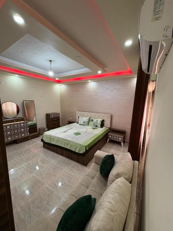 a bedroom with a bed and a couch in it at الوليد للشقق المفروشة in Amman
