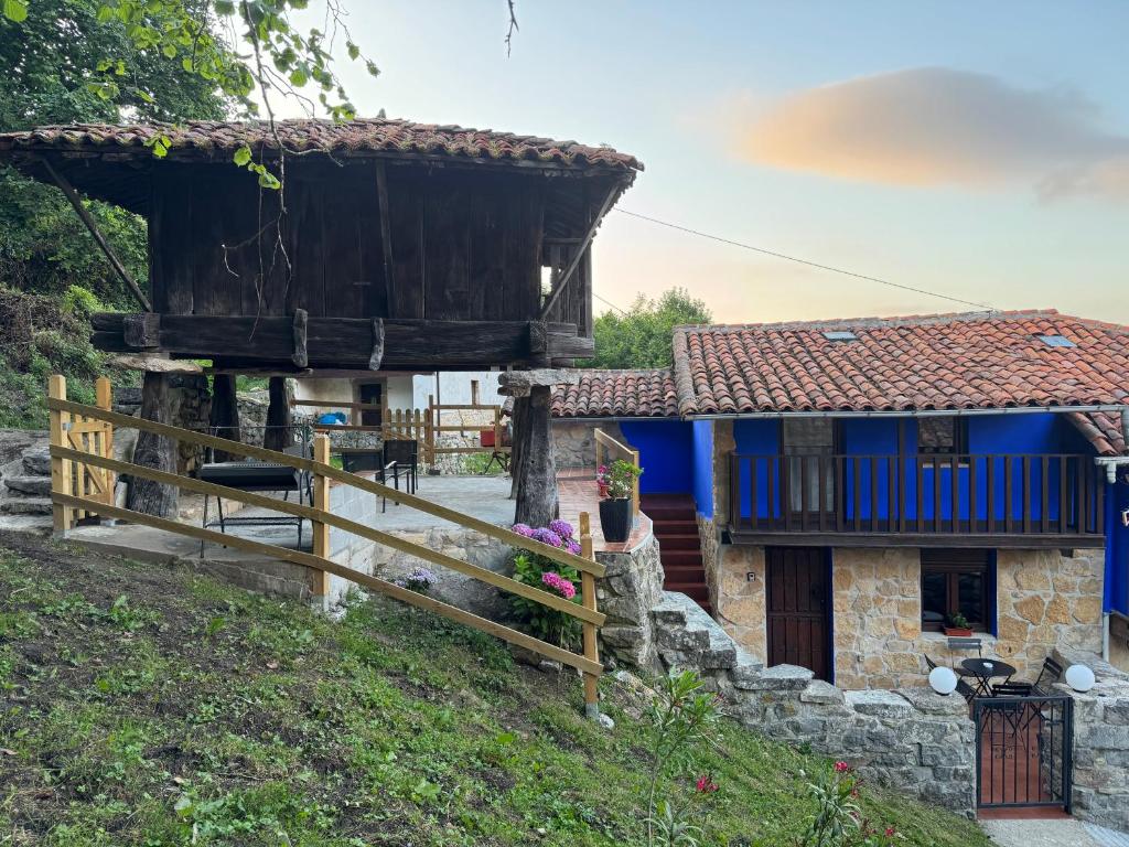 a house with a fence and a blue house at La Casina del Trasgu in Cangas de Onís