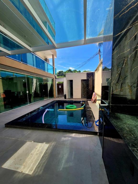 a swimming pool in the middle of a house at Pousada Terraço do Peró Cabo Frio Há 200 metros da Praia in Cabo Frio
