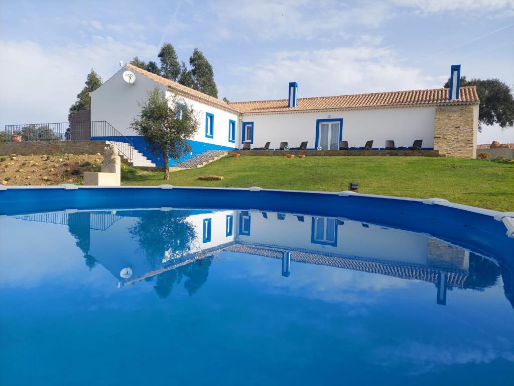 a house and a swimming pool in front of a house at Monte do Sol in São Luis