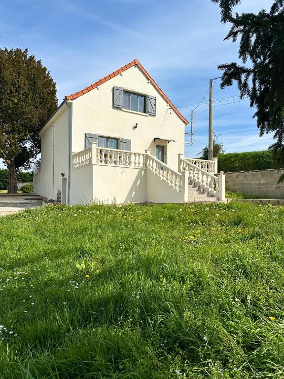 a white house with a fence in the grass at Maison de vacances campagnes in La Celle-Guénand
