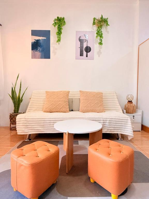 a living room with a couch and a table and two chairs at Casita del Mabini - Homestay in Mabini