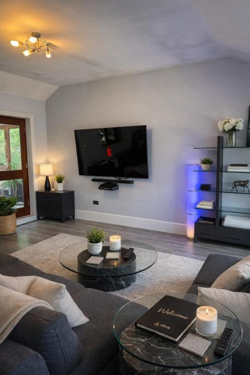 a living room with a couch and a flat screen tv at Lower Barn in Lapford