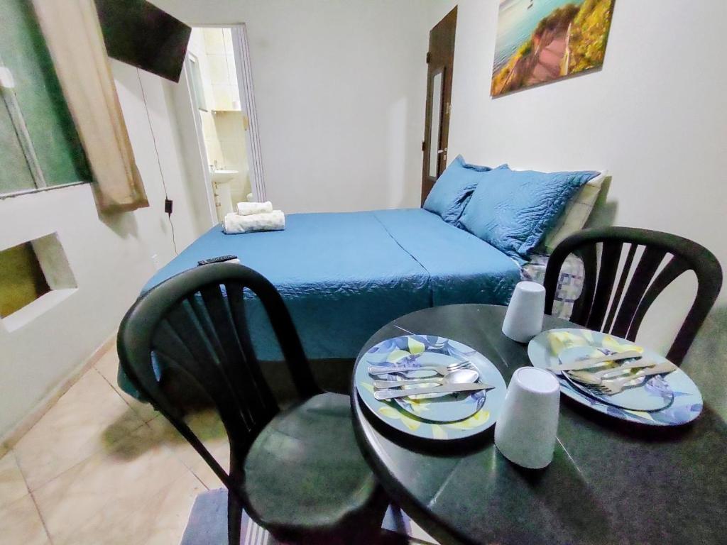 a small room with a table and a bed at Solares Aconchego - Suíte in Búzios