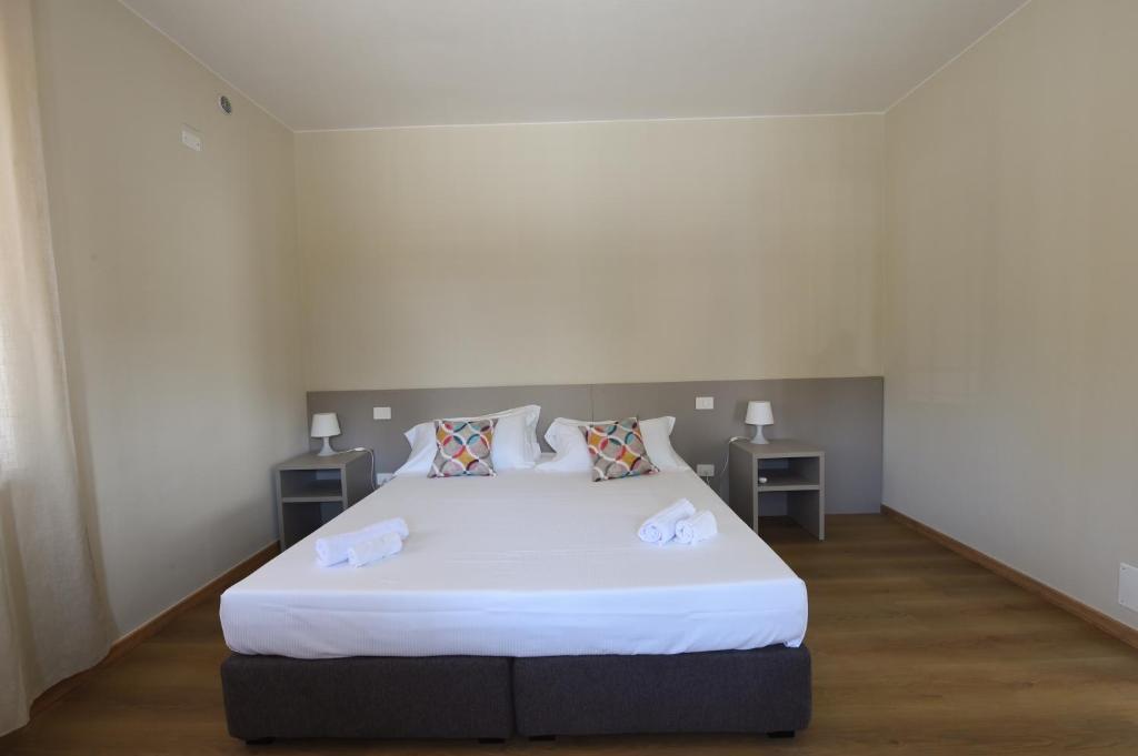 a bedroom with a large white bed with two tables at Affittacamere Marilù in Paratico