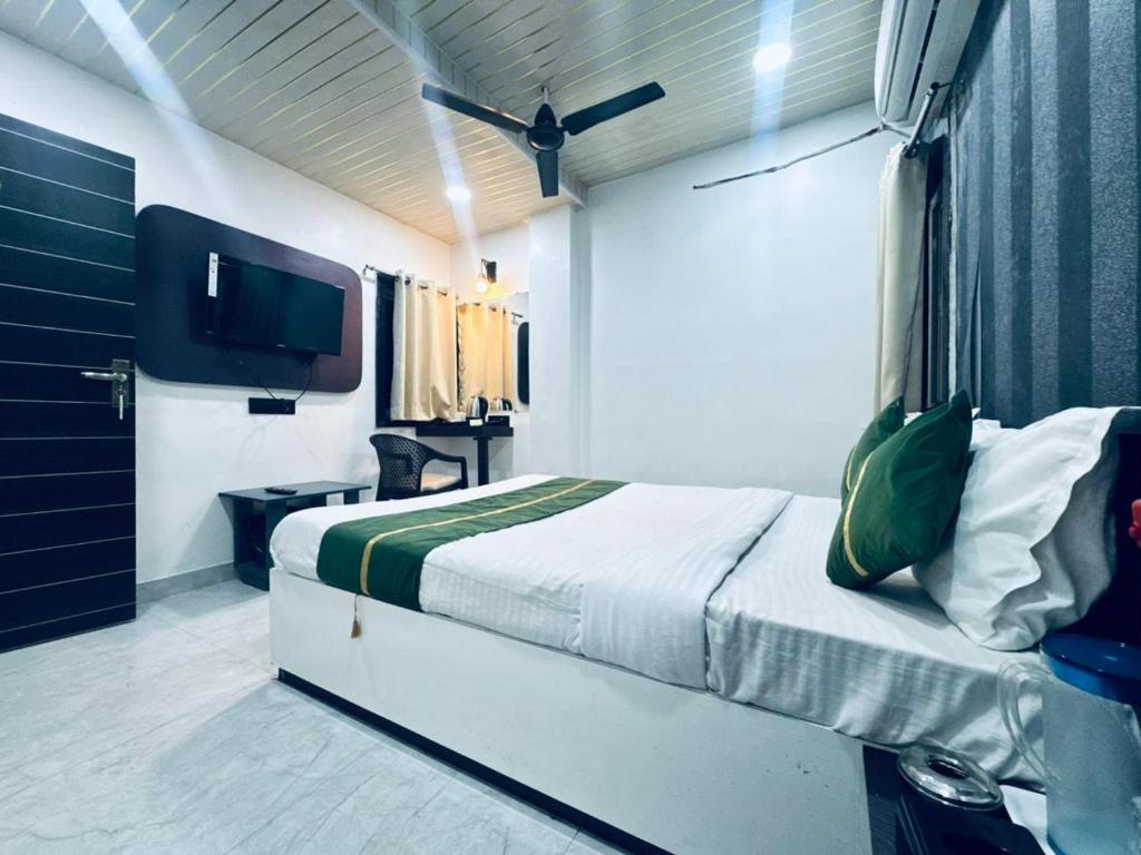 a bedroom with a bed and a flat screen tv at Hotel Green Valley in Raipur