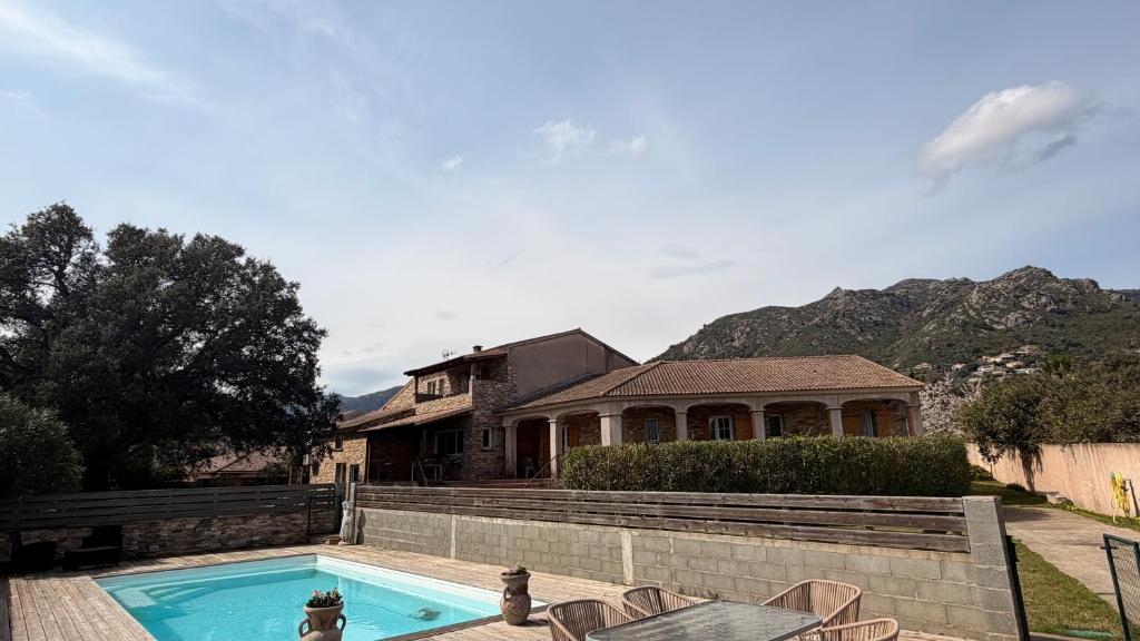a house with a swimming pool in front of a house at Villa Bella Vita in Biguglia