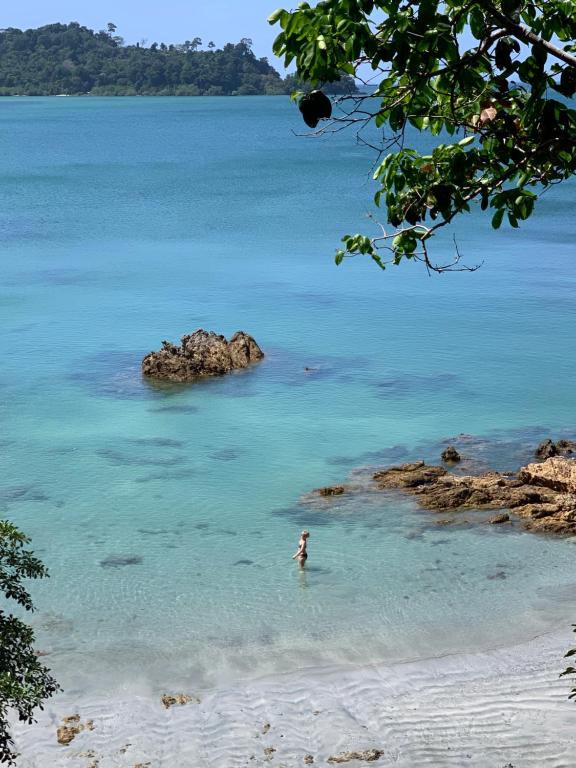 a person standing in the water on a beach at Spiral Resort in Ko Phayam