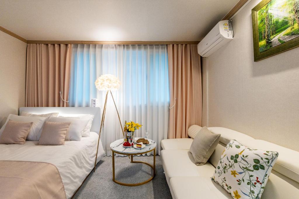 a hotel room with a couch and a table at 홍대 골든스테이 in Seoul