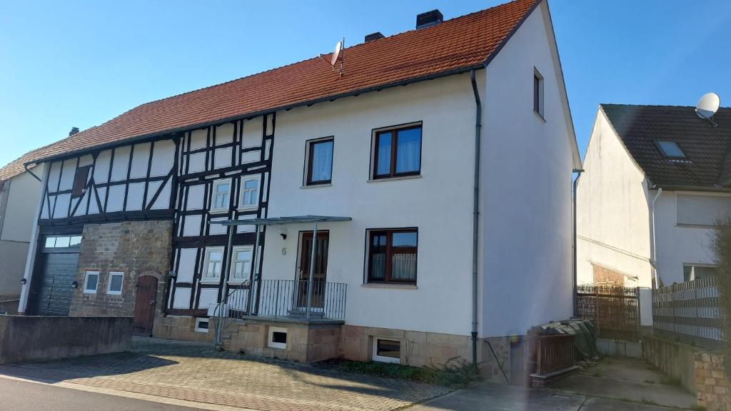 a white and black house with a red roof at Ferienhaus Bernhardine in Knüllwald