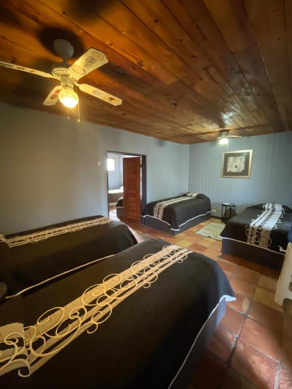 a bedroom with two beds and a ceiling fan at Rm Dorm in San Quintín