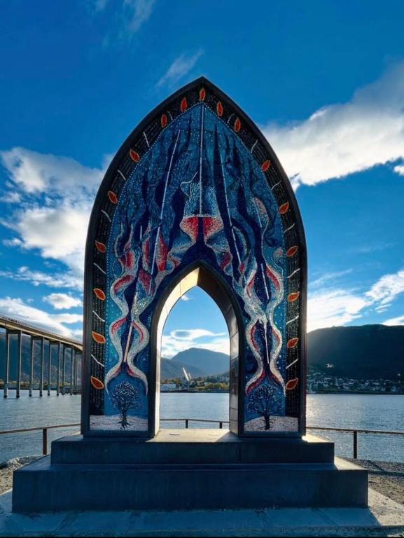 a stained glass archway in front of a body of water at Stille leilighet med topp beliggenhet i Tromsø sentrum in Tromsø