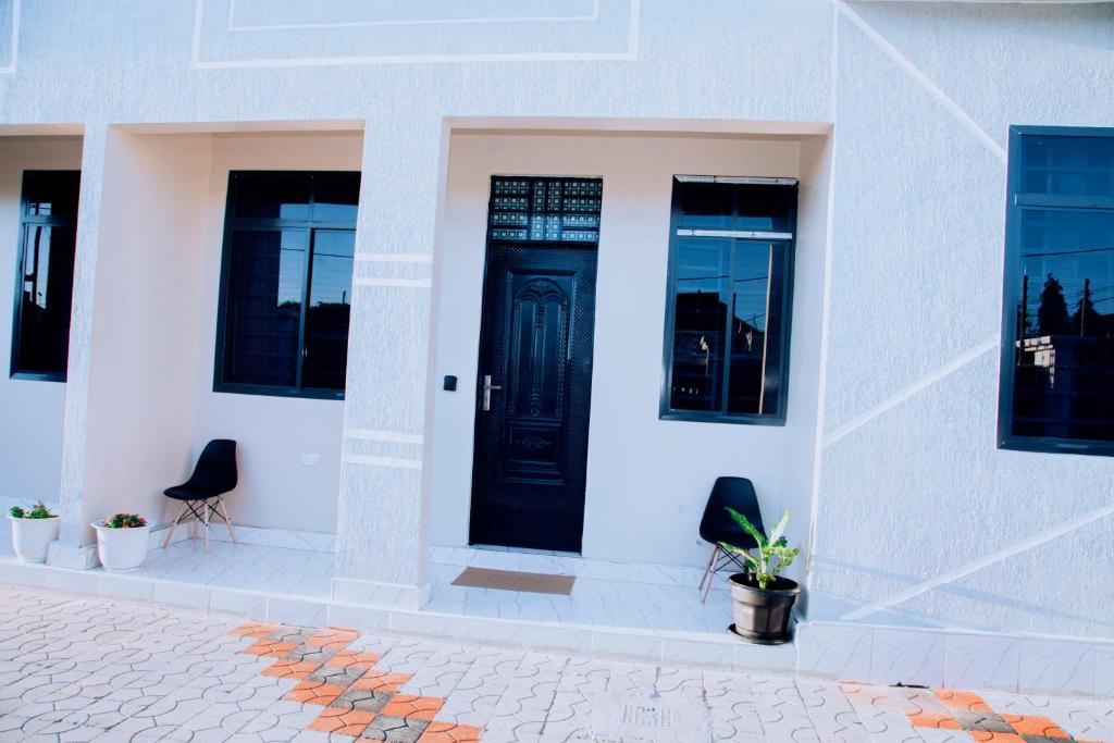 a white house with a black door and windows at Dodoma Haven Homes in Dodoma