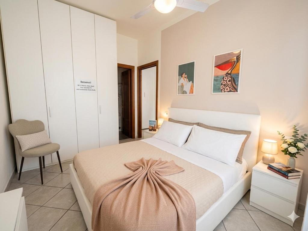 a bedroom with a large white bed and a chair at appartamento a careggi casa diamante in Florence
