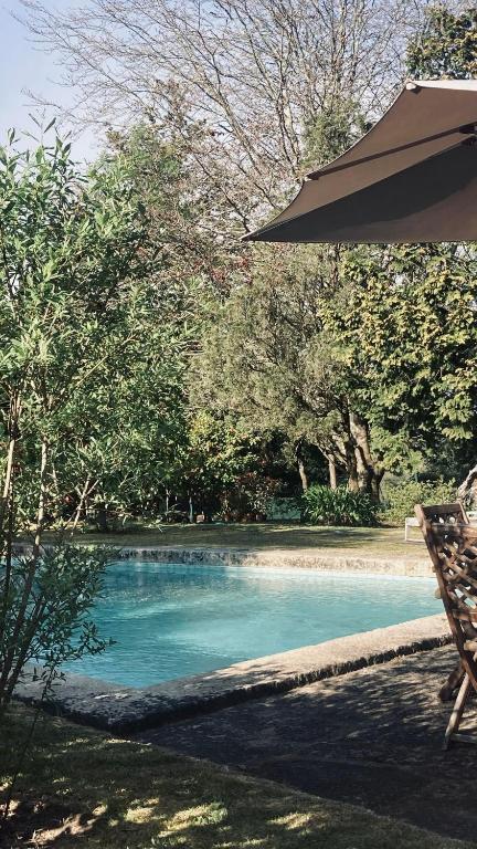 a pool of blue water with an umbrella next to it at Casa de Margacide in Vila Nova de Cerveira